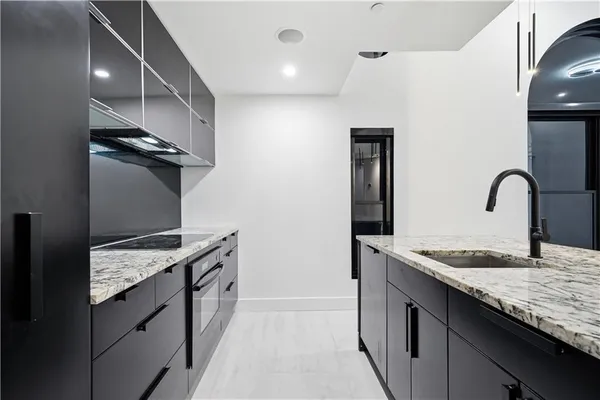 a kitchen with granite countertop cabinets a sink and a large window