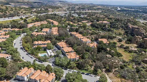 an aerial view of residential houses with city and green space