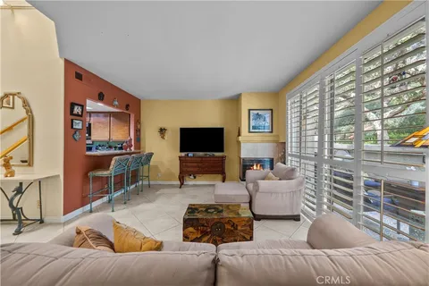 a living room with furniture a flat screen tv and a large window