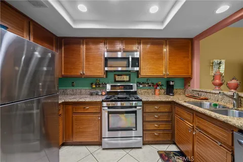 a kitchen with stainless steel appliances granite countertop a stove a refrigerator and a sink