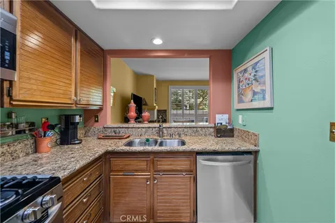 a kitchen with stainless steel appliances granite countertop a sink and a wooden cabinets