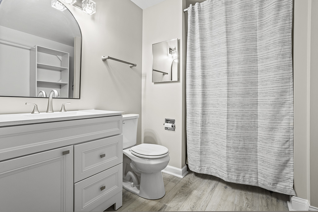 3913 Saratoga Avenue, Unit G306 Downers Grove, IL 60515 - Photo 12 of 18 a bathroom with a sink a toilet and shower curtain
