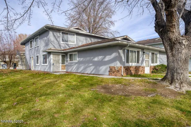 a front view of a house with yard and green space
