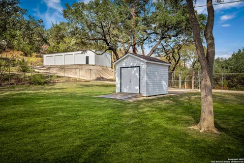 a view of a yard in front of a house with large trees
