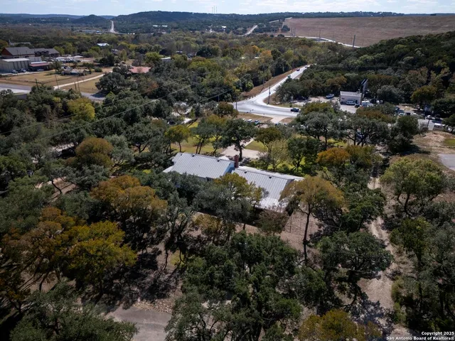 an aerial view of residential house with green space and mountain view
