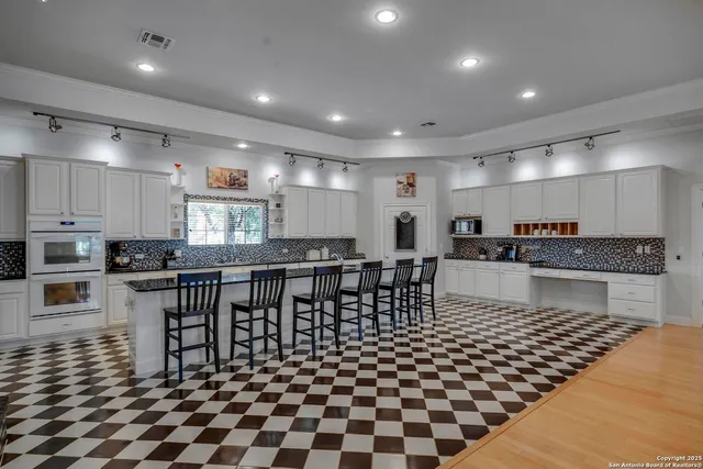a kitchen with a dining table chairs and white stainless steel appliances