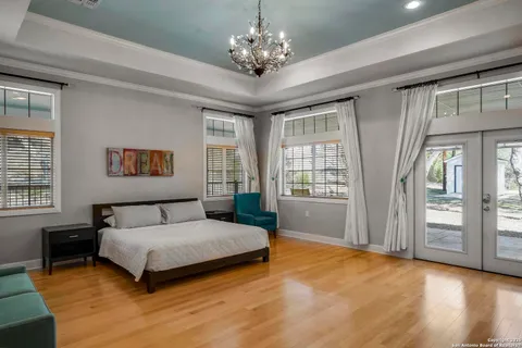 a bedroom with a large bed chandelier and a window
