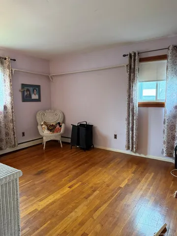 a room with wooden floor and book shelf