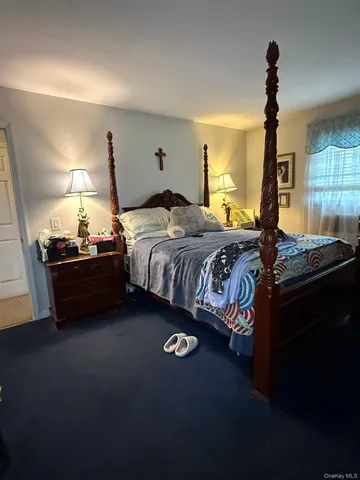 a view of an empty room with wooden floor fireplace and a window
