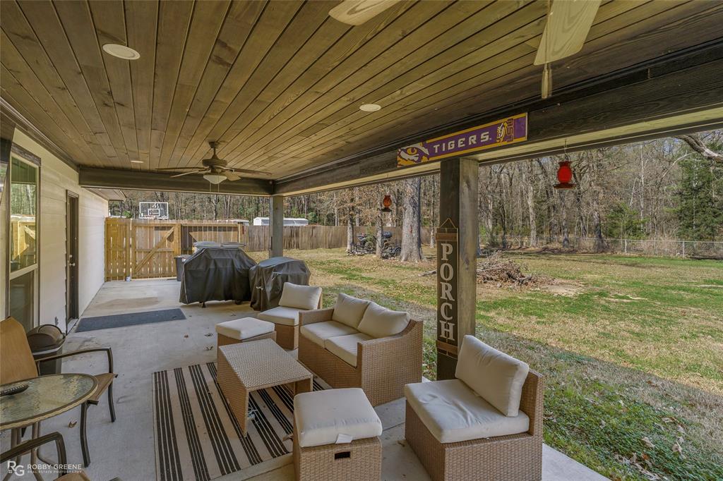 396 Collinswood Road Stonewall, LA 71078 - Photo 2 of 32 a view of a patio with table and chairs and floor to ceiling window with wooden floor