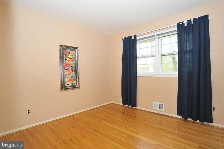 5613 Rathbone Place Springfield, VA 22151 - Photo 10 of 22 a view of an empty room with wooden floor and a window