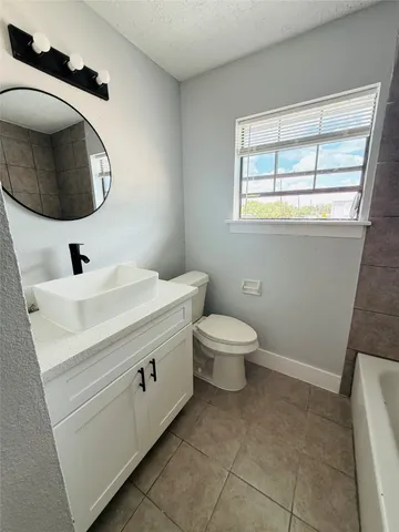 a bathroom with a toilet a sink and mirror