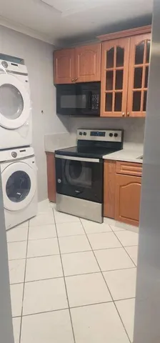 a kitchen with granite countertop a stove a sink and a microwave