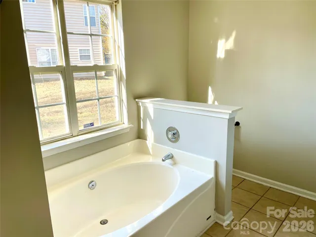 a bathroom with a tub and a window