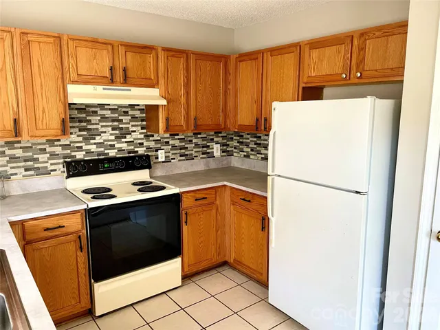 a kitchen with a stove a refrigerator and a sink