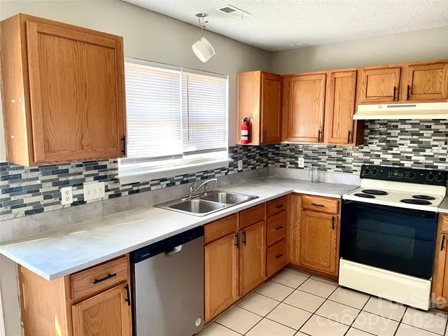 a kitchen with a sink stove top oven and cabinets