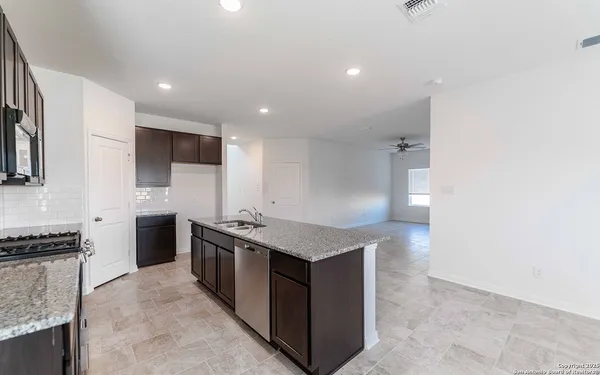a kitchen with stainless steel appliances granite countertop a stove a sink and a refrigerator