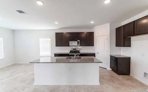 a large kitchen with stainless steel appliances a large counter top