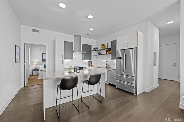 a kitchen with stainless steel appliances kitchen island granite countertop a refrigerator and a stove top oven