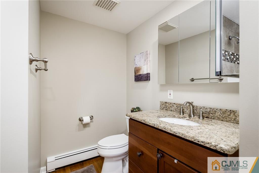 16 Ryan Road Cranbury, NJ 08512 - Photo 12 of 24 a bathroom with a granite countertop sink a toilet and a mirror