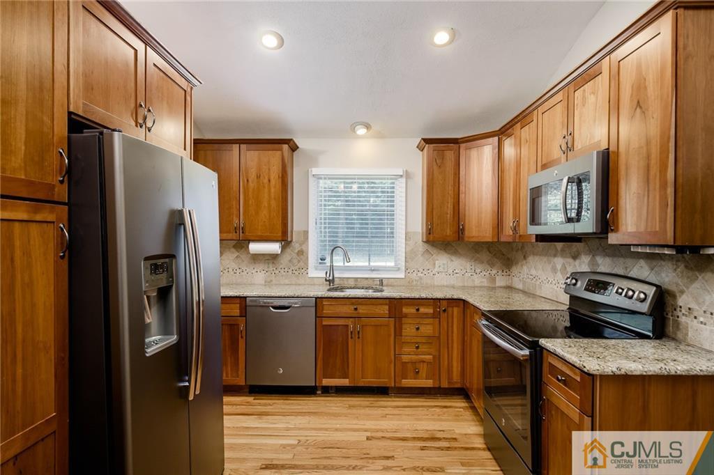 16 Ryan Road Cranbury, NJ 08512 - Photo 3 of 24 a kitchen with stainless steel appliances granite countertop a refrigerator a stove and a sink