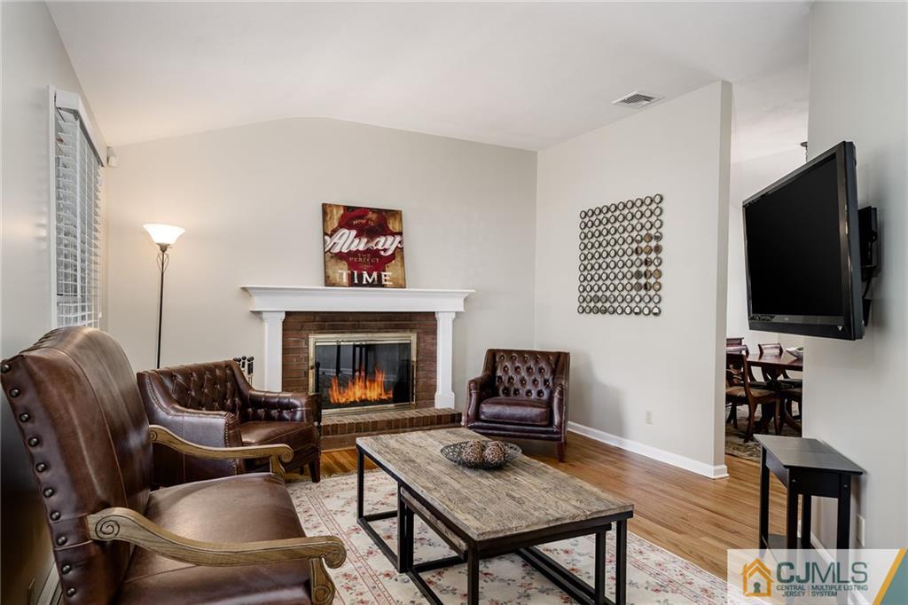 16 Ryan Road Cranbury, NJ 08512 - Photo 5 of 24 a living room with furniture a flat screen tv and a fireplace