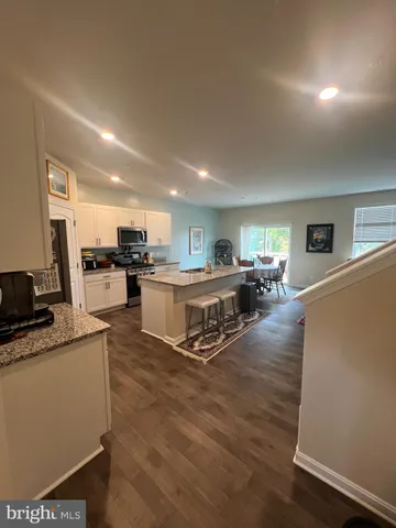 a living room with lots of furniture and kitchen view