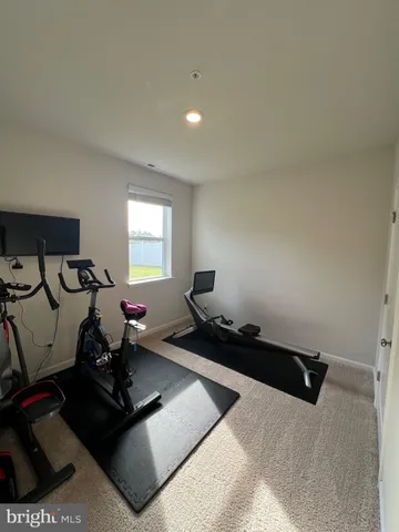 a view of a hallway with wooden floor and a bathroom