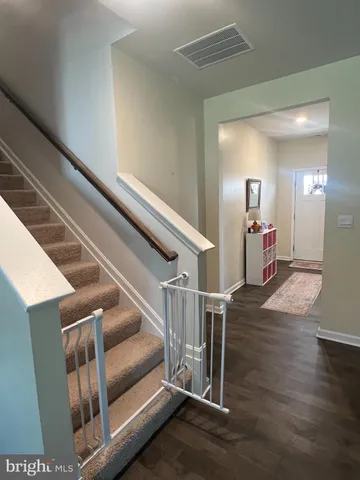 a view of a hallway with wooden floor and entryway