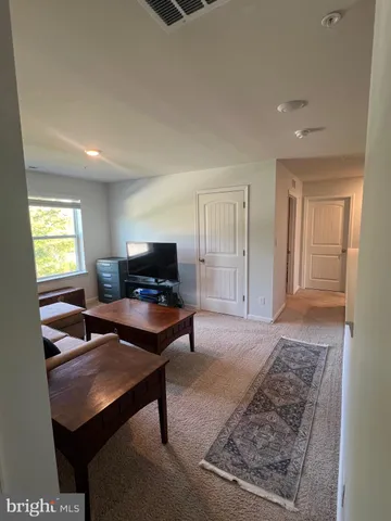 a spacious bedroom with a bed and a lamp