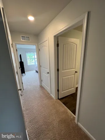 a spacious bedroom with a bed and wooden floor