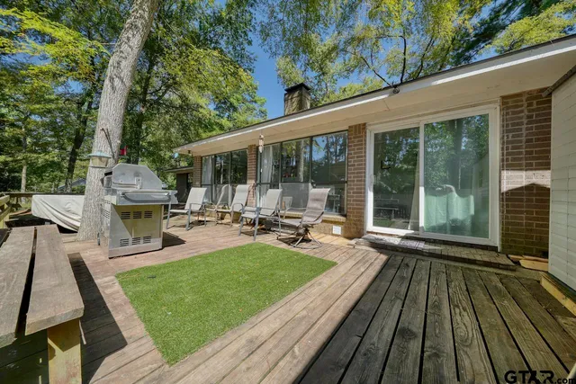 a view of a patio with table and chairs wooden floor and fence