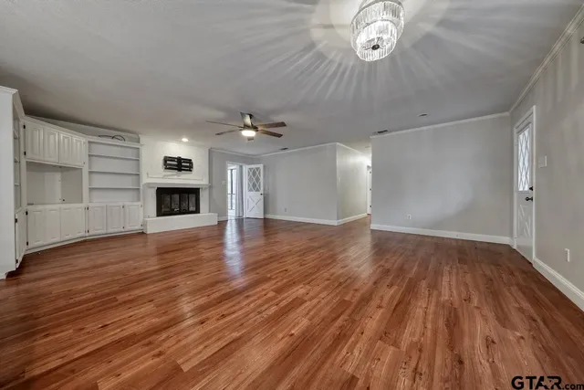 a view of empty room with wooden floor