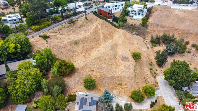 an aerial view of a house with a yard and greenery