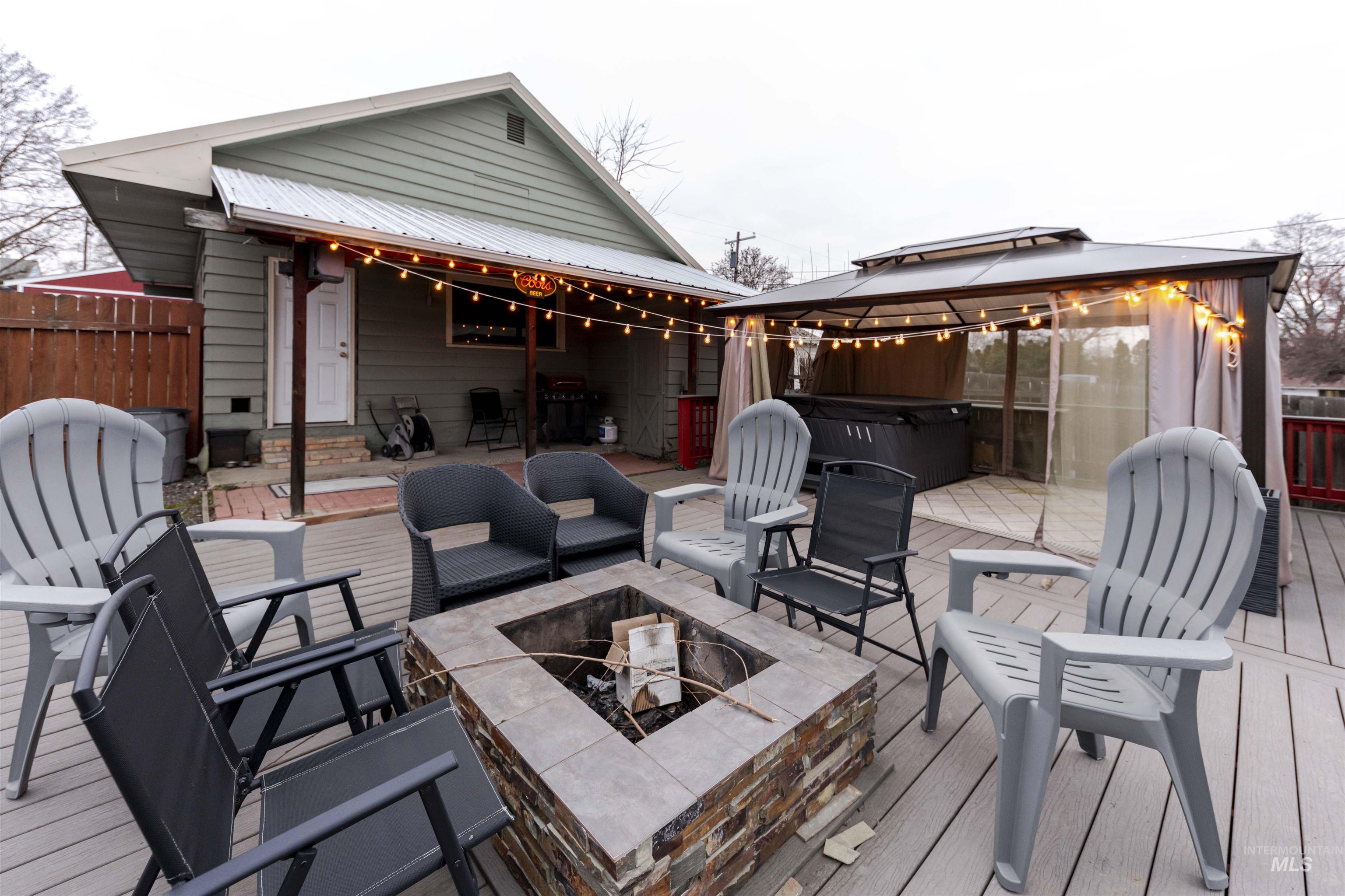 1906 15th Avenue Lewiston, ID 83501 - Photo 11 of 18 Deck with a gazebo, a hot tub, and an outdoor living space with a fire pit