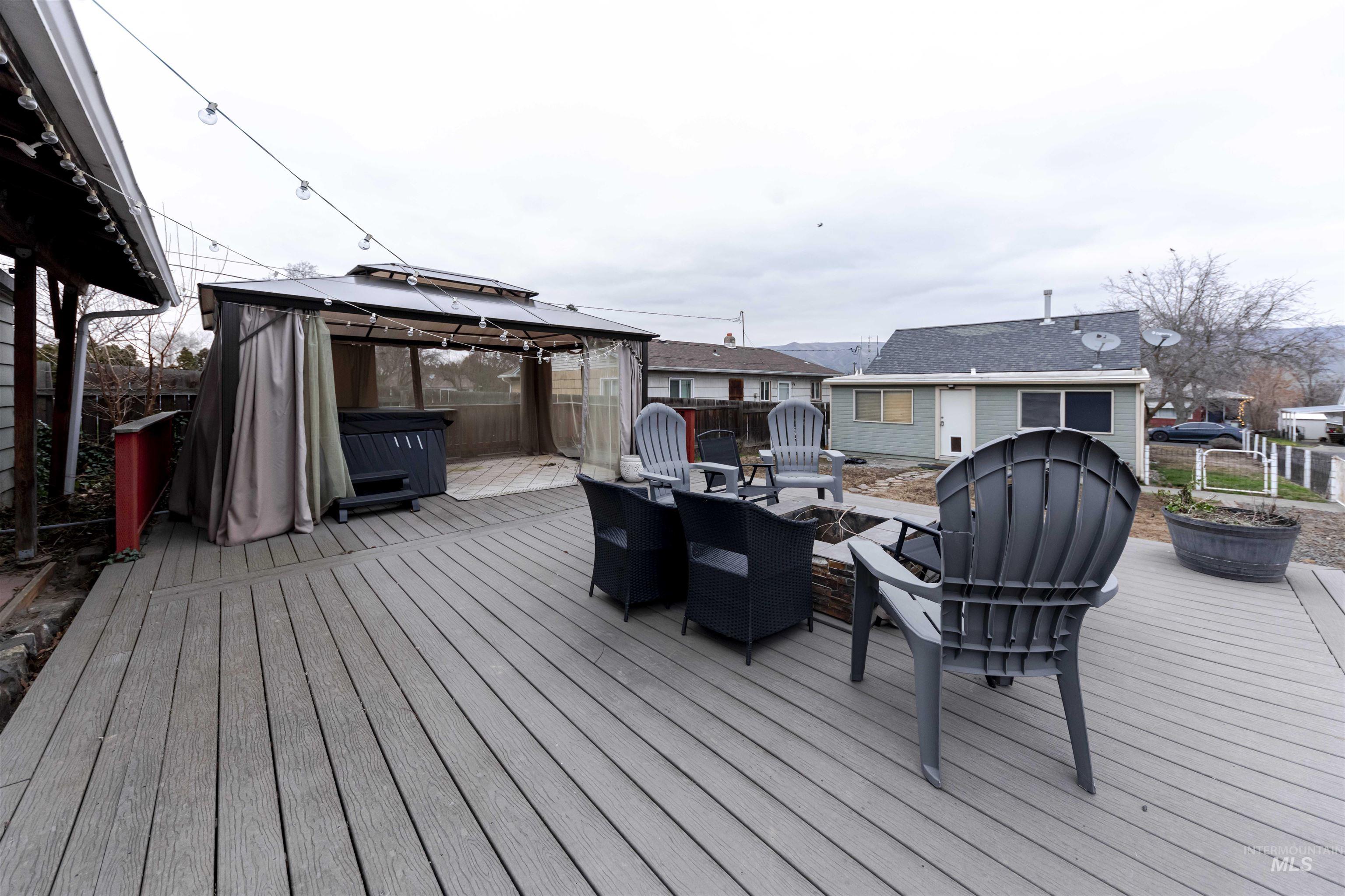1906 15th Avenue Lewiston, ID 83501 - Photo 12 of 18 Deck featuring an outdoor fire pit, a gazebo, a fenced backyard, and a hot tub
