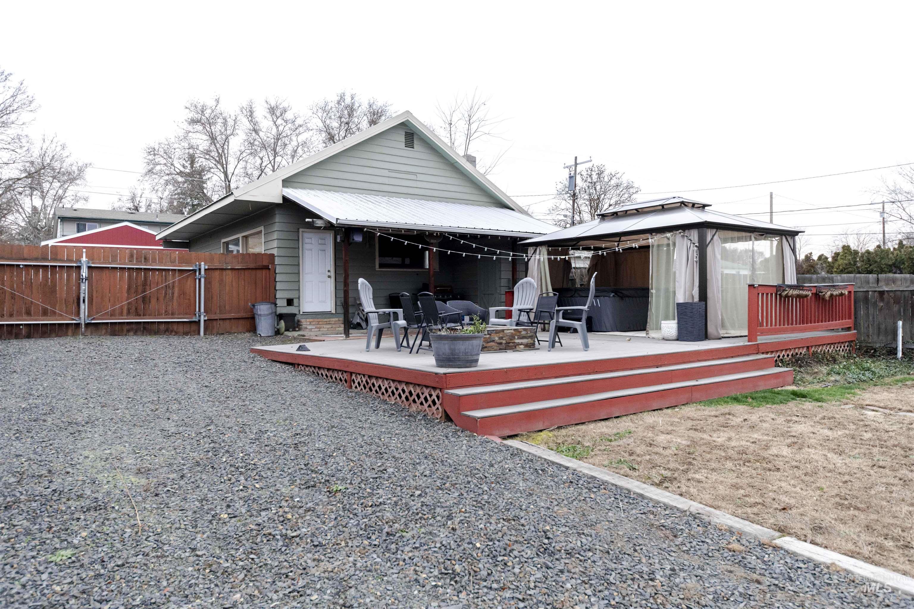 1906 15th Avenue Lewiston, ID 83501 - Photo 14 of 18 Back of property featuring a gate, a gazebo, a fire pit, a metal roof, and a wooden deck