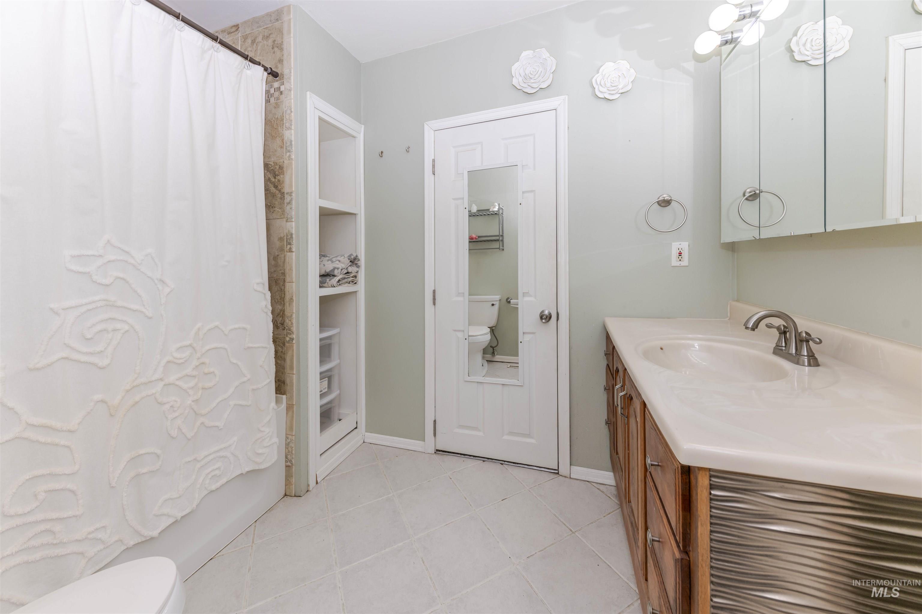 1906 15th Avenue Lewiston, ID 83501 - Photo 5 of 18 Full bathroom featuring vanity, light tile patterned floors, shower / bath combo, and a closet