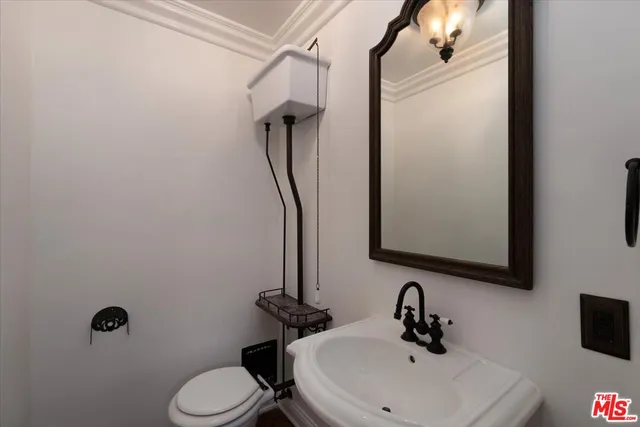 a view of a hallway with wooden floor and a chandelier fan