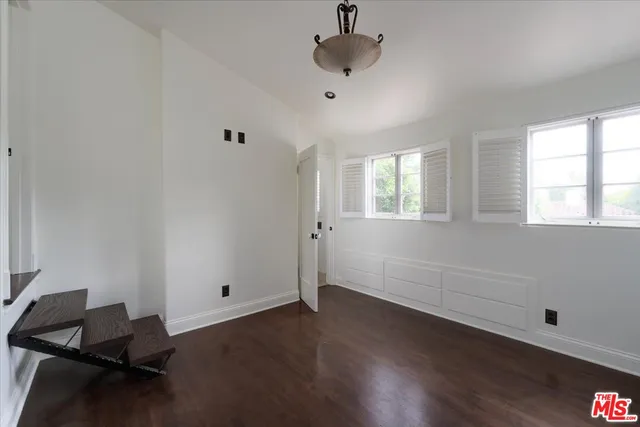 a view of a white house with swimming pool table and chairs