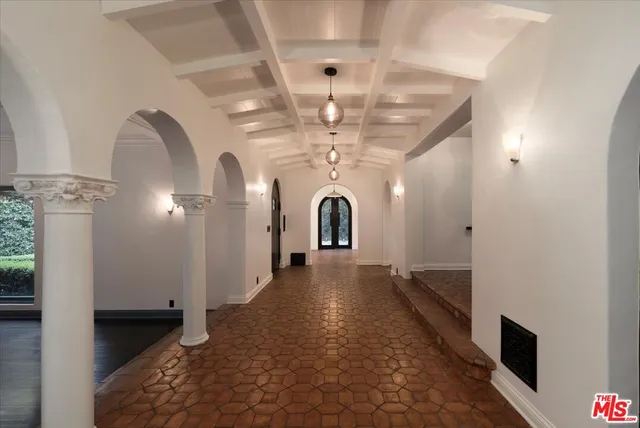an empty room with wooden floor fireplace and windows