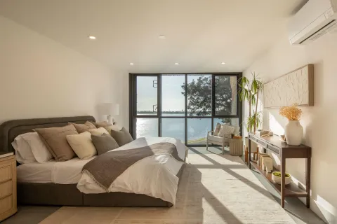 a spacious bedroom with a large bed and a large window