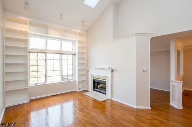 a view of an empty room with a window and fireplace