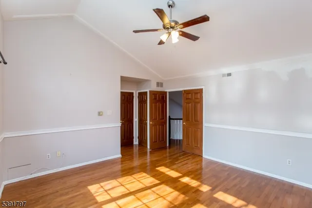 a view of a livingroom with a ceiling fan and wooden floor