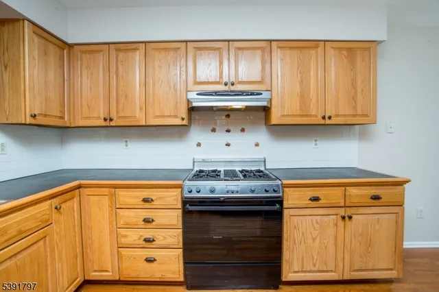 a kitchen with granite countertop cabinets and a wooden floor