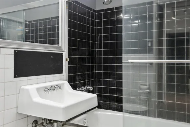 a bathroom with a sink a toilet a mirror and shower