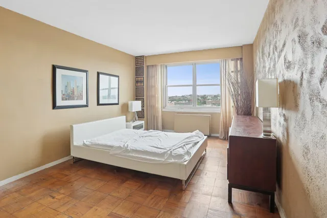 a bedroom with a bed and wooden floor