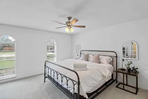 3130 Barton Road Carrollton, TX 75007 - Photo 7 of 16 a bedroom with a bed and a chandelier