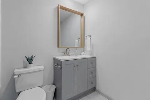 3130 Barton Road Carrollton, TX 75007 - Photo 9 of 16 a bathroom with a toilet a sink and mirror