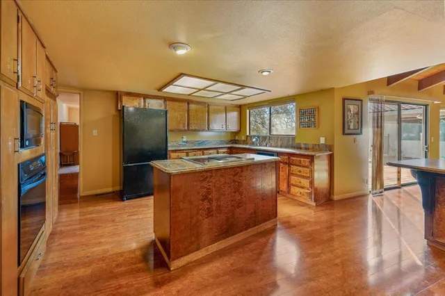 a kitchen with stainless steel appliances granite countertop a stove a sink and a refrigerator